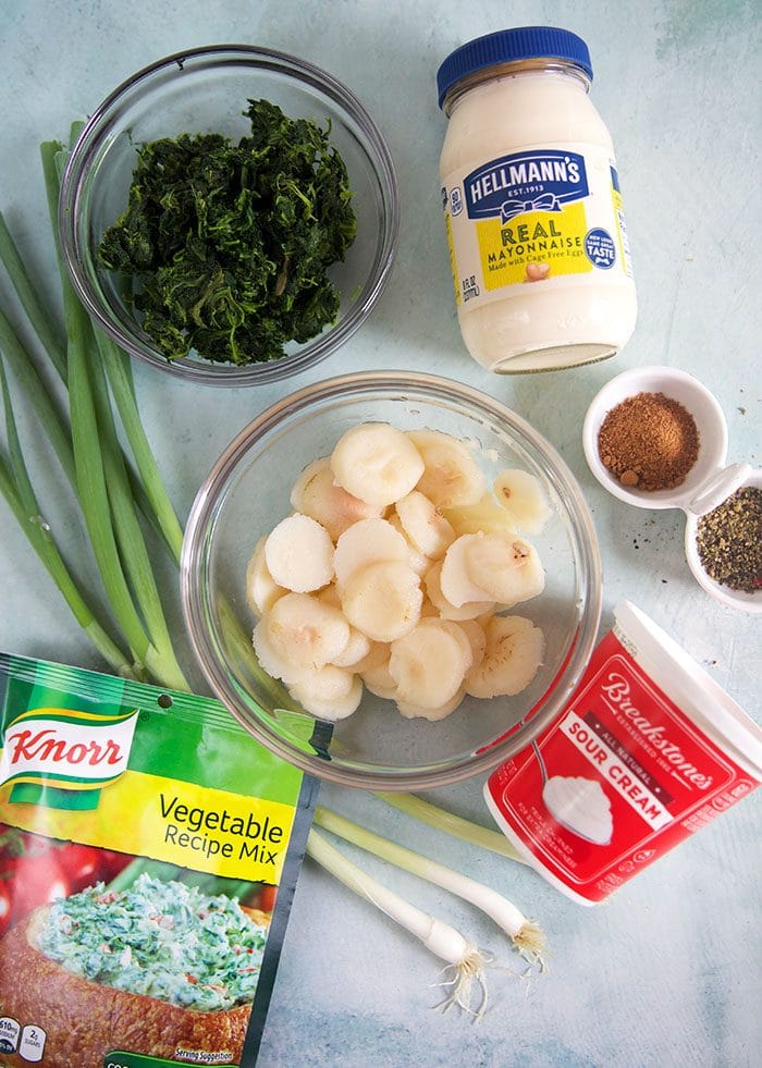 Ingredients for Knorr Spinach Dip on a blue background.