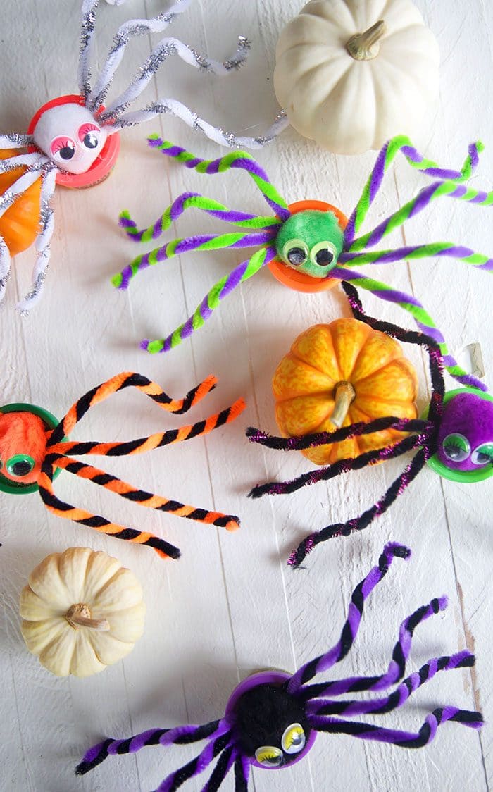Overhead shot of Play doh spiders on a white background.