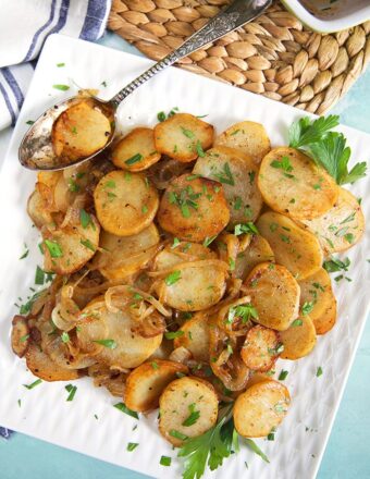 Overhead shot of Lyonnaise potatoes on a square platter.