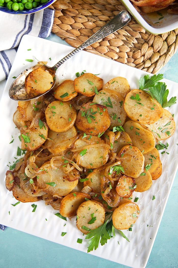 Overhead shot of Lyonnaise potatoes on a square platter.
