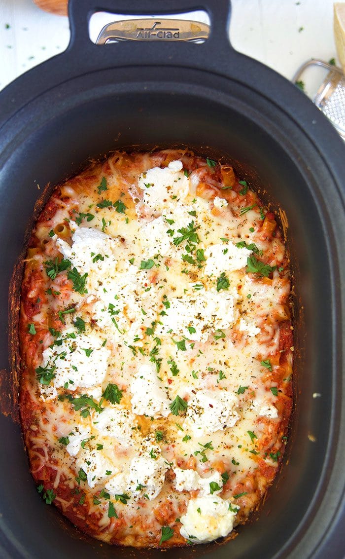 Slow cooker baked ziti in a crock pot with melted cheese on top.
