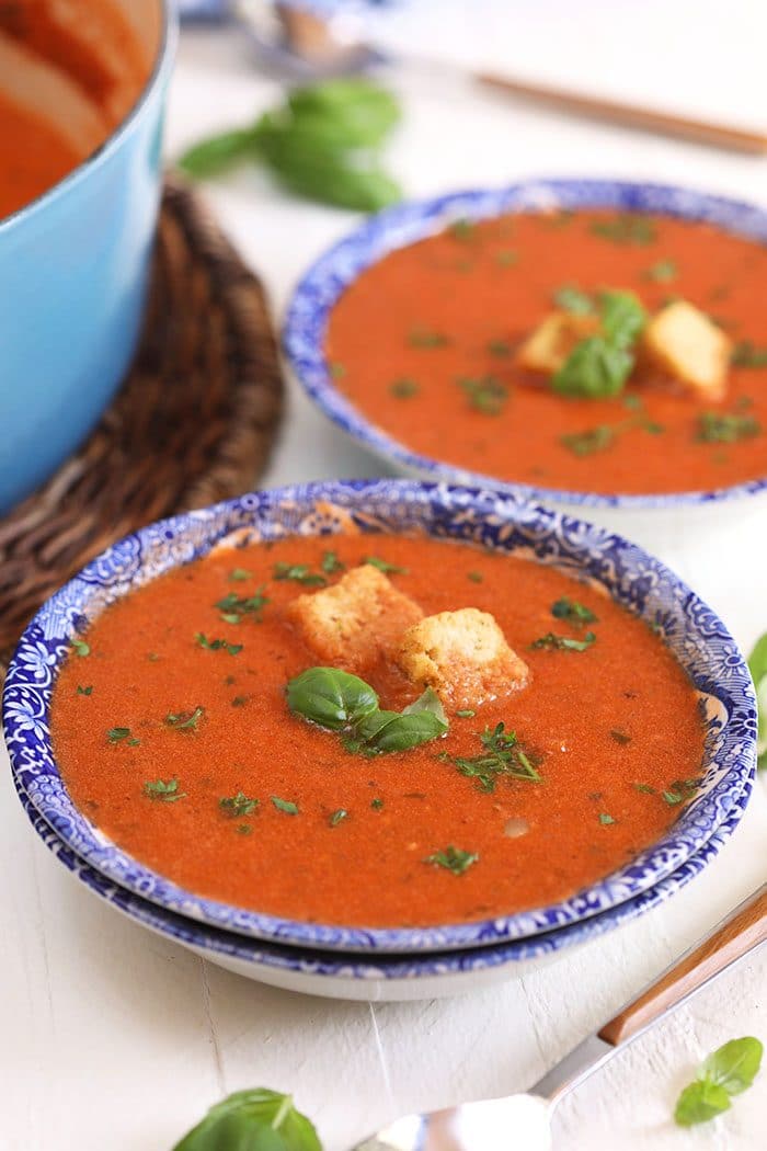 Tomato Basil Bisque in a blue and white bowl on a white background.