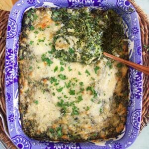 overhead shot of creamed spinach gratin in a blue and white baking dish.