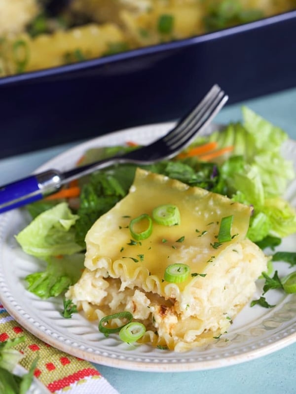 Pierogi Casserole on a white plate with a green salad.