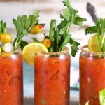 Bloody Mary Mix in a glass with celery and olives.