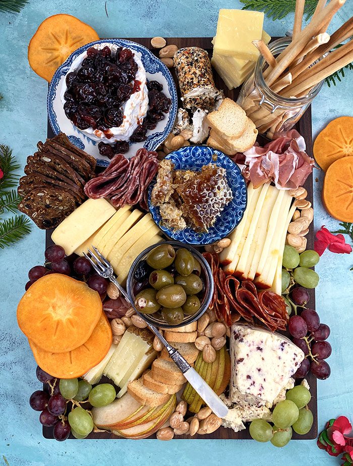 Overhead shot of charcuterie board on a blue background.