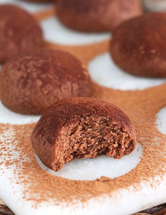 Close up of chocolate shortbread cookies with a bite taken out of it.