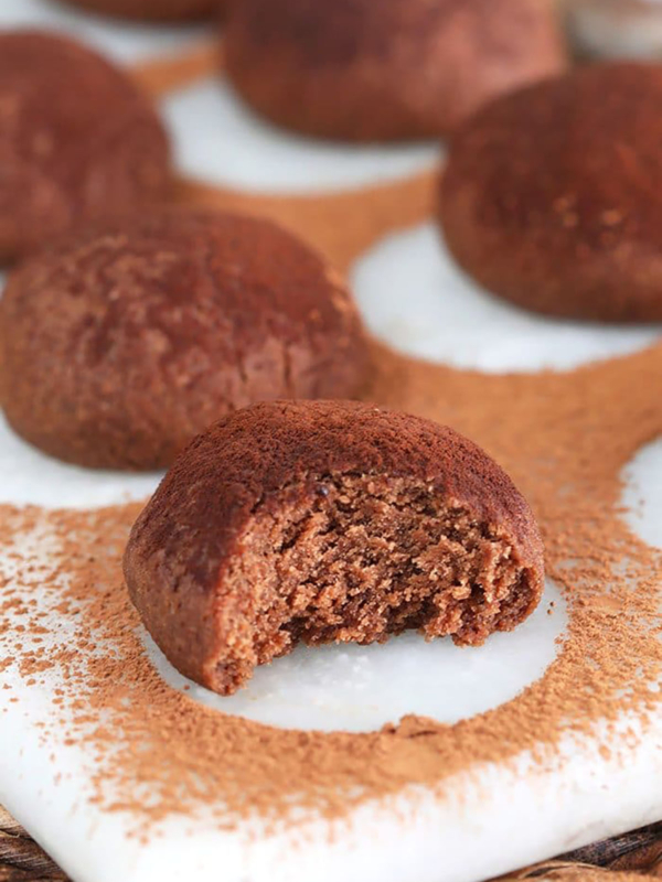 Close up of chocolate shortbread cookies with a bite taken out of it.