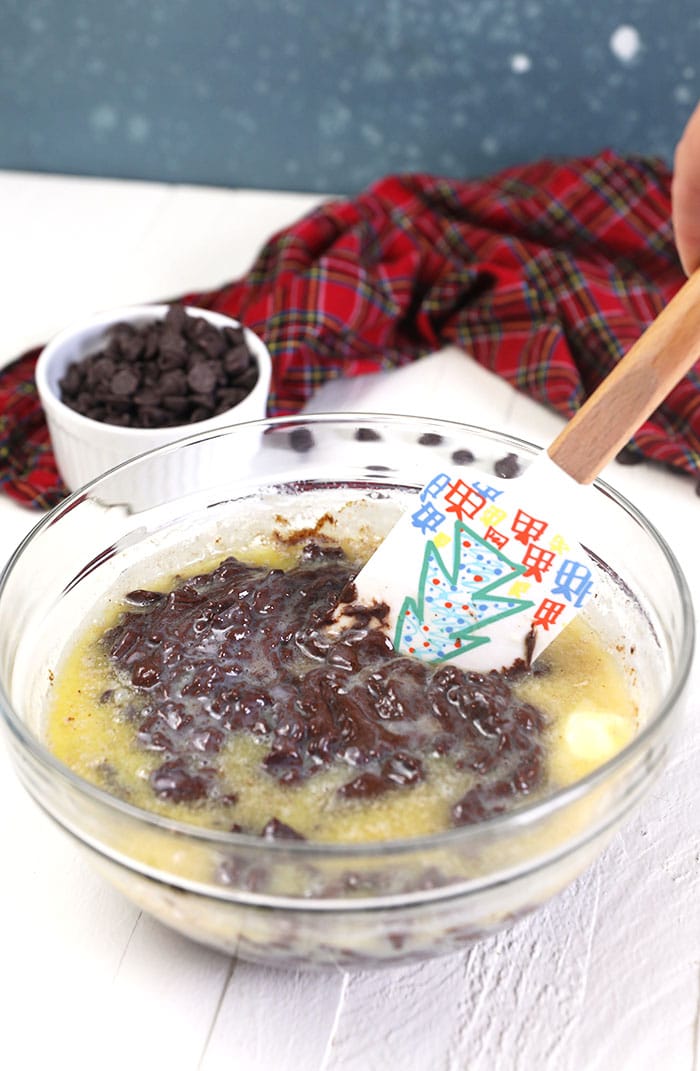 A festive mixing spoon is stirring a glass bowl of ingredients.