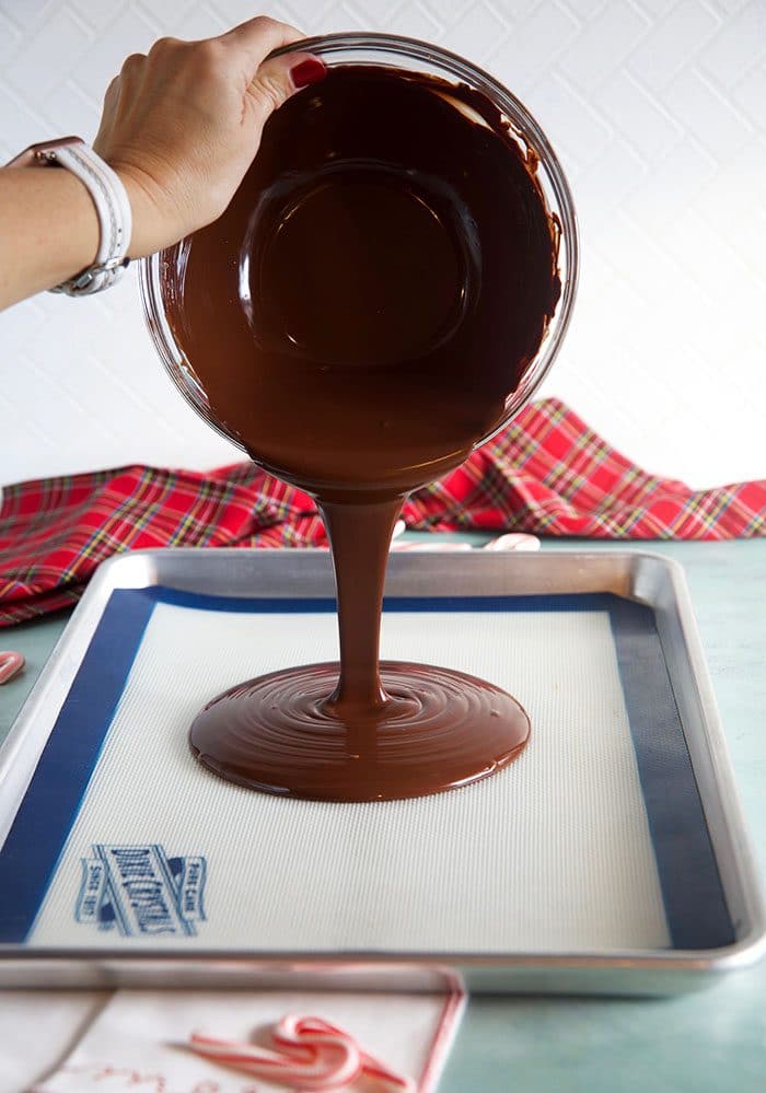 Dark chocolate being poured onto a baking sheet.