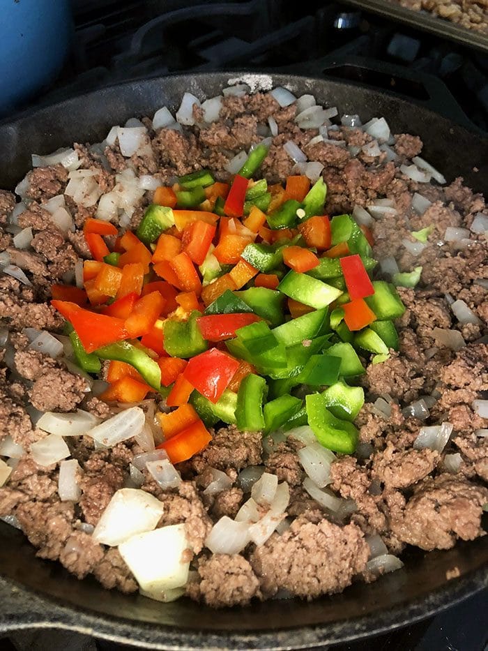ground beef, bell peppers and onion in a cast iron skillet.