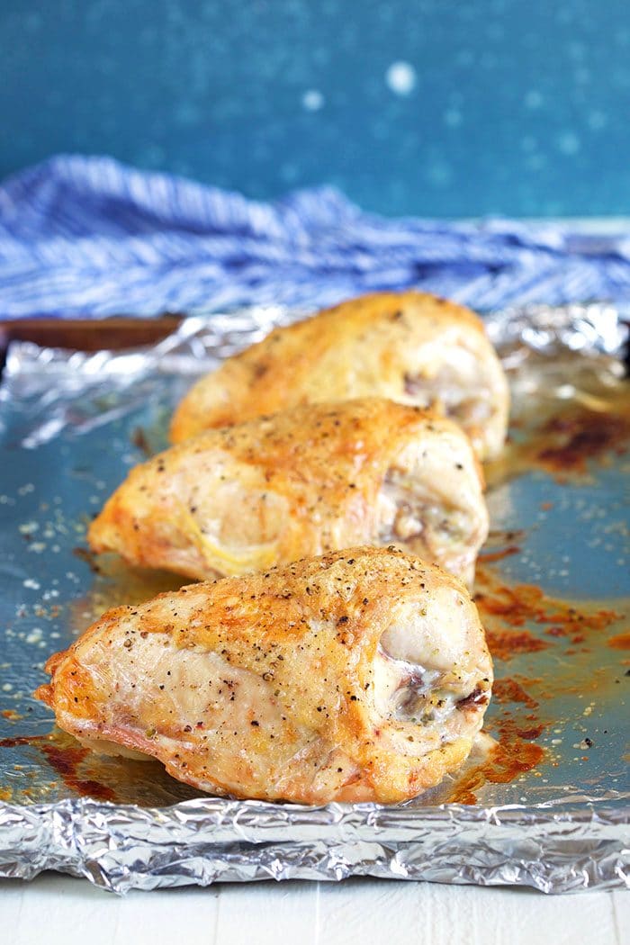 Roasted chicken breast on a baking sheet.