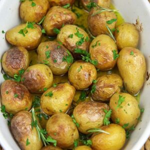 Oven roasted baby potatoes in a white casserole dish.