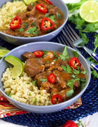 Thai Red Curry Beef Stew on a bed of couscous in a blue bowl.