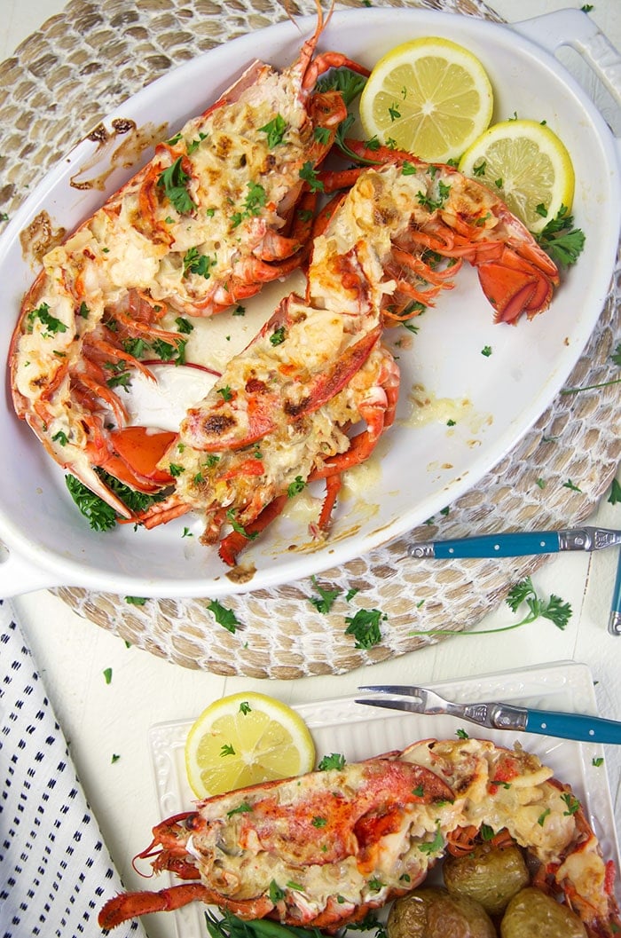 Overhead lobster thermidor in a baking dish with lemons.