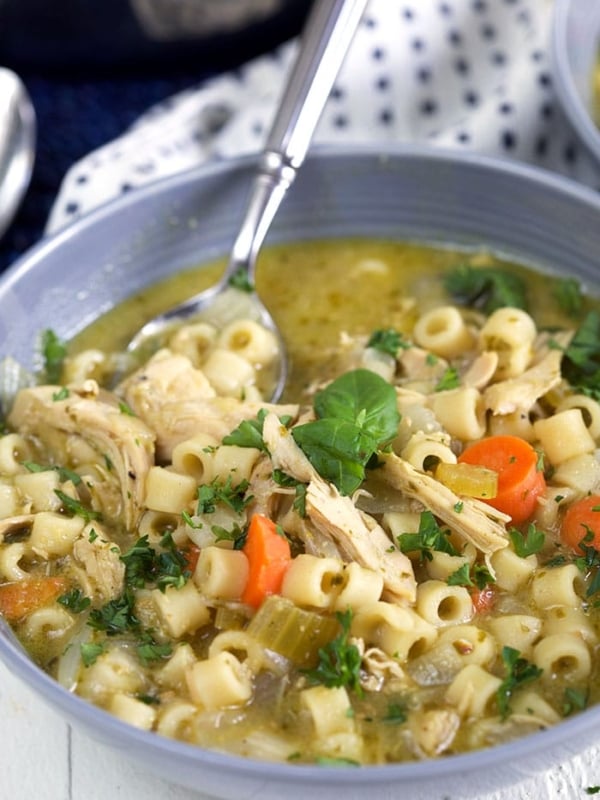 Chicken Noodle Soup in a gray bowl on a white background.