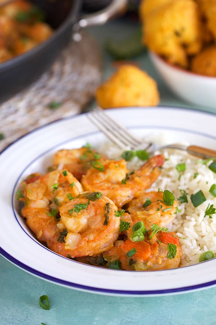 Close up of shrimp etouffee in a white bowl with rice.
