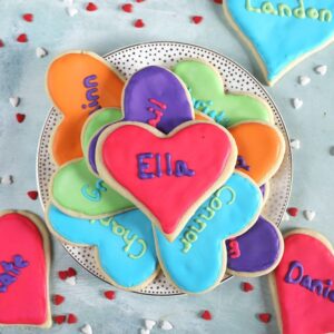 Overhead shot of valentine sugar cookies on a white plate.