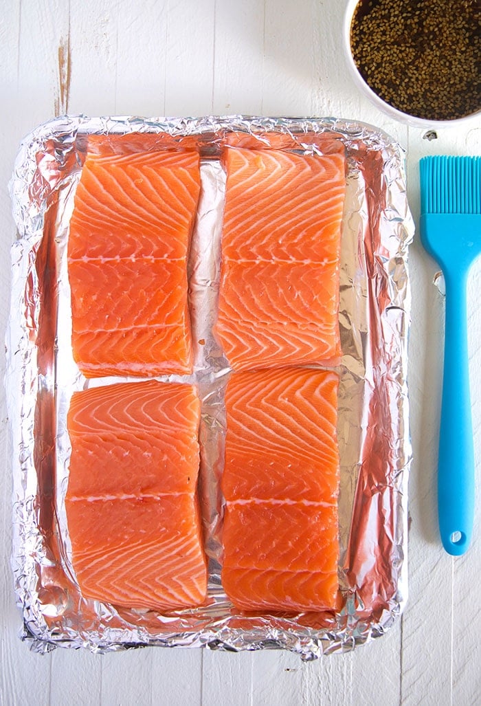 Overhead shot of salmon filets on a baking sheet lined with foil.