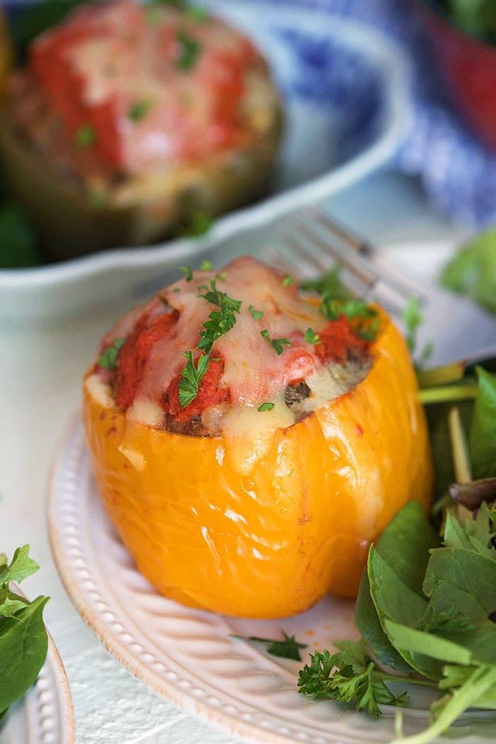 Stuffed yellow bell pepper on a white plate.