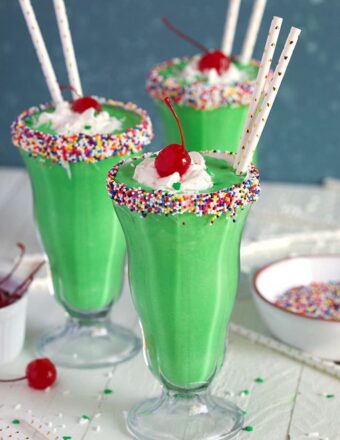 Shamrock Shake in a milkshake glass with sprinkles and whipped cream.