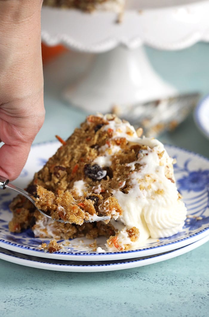 Slice of carrot cake on a blue and white plate.