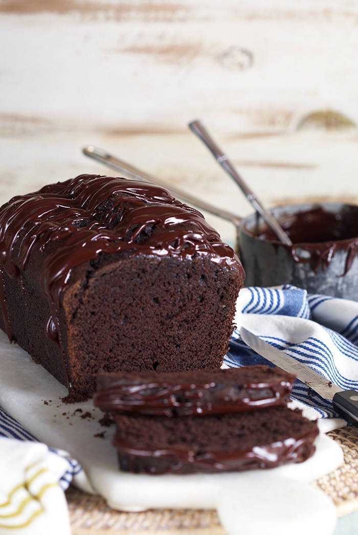 Double Chocolate Banana bread with a pot of chocolate glaze in the background.