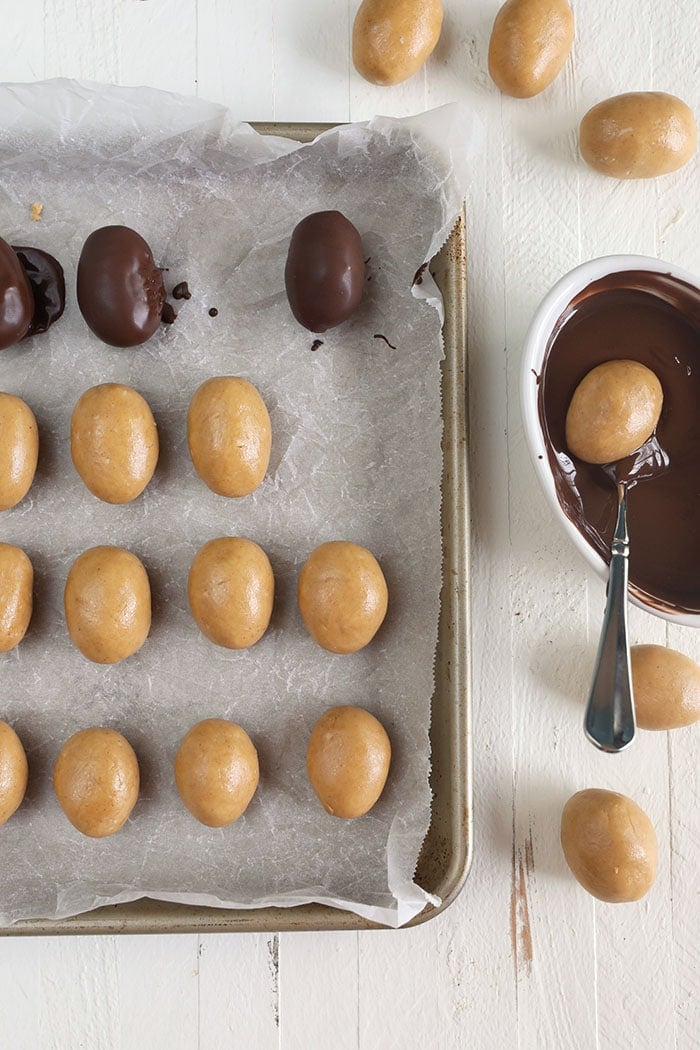 Peanut butter eggs being dipped in chocolate.