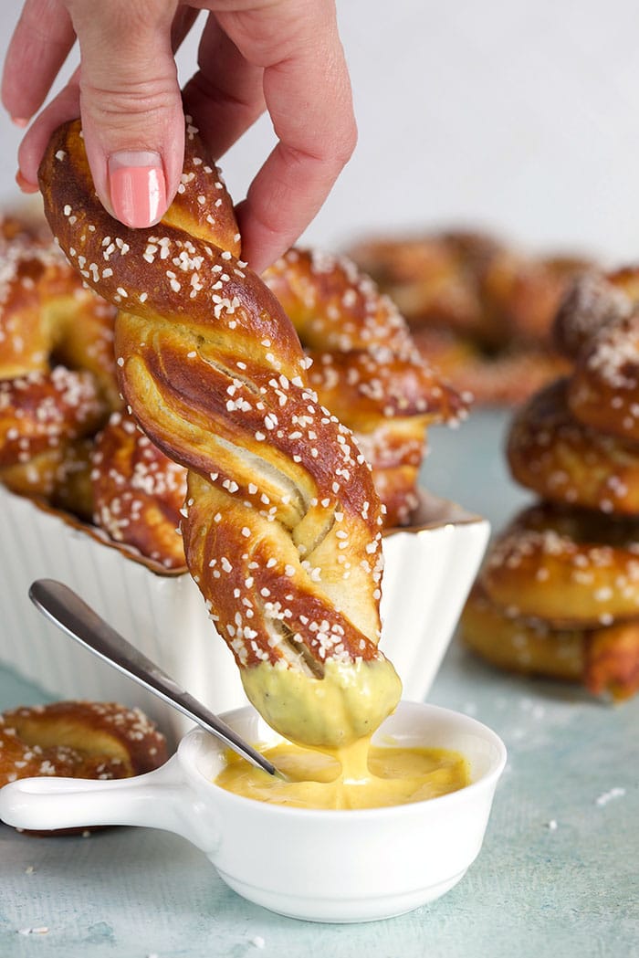 Soft Pretzel being dipped into mustard.