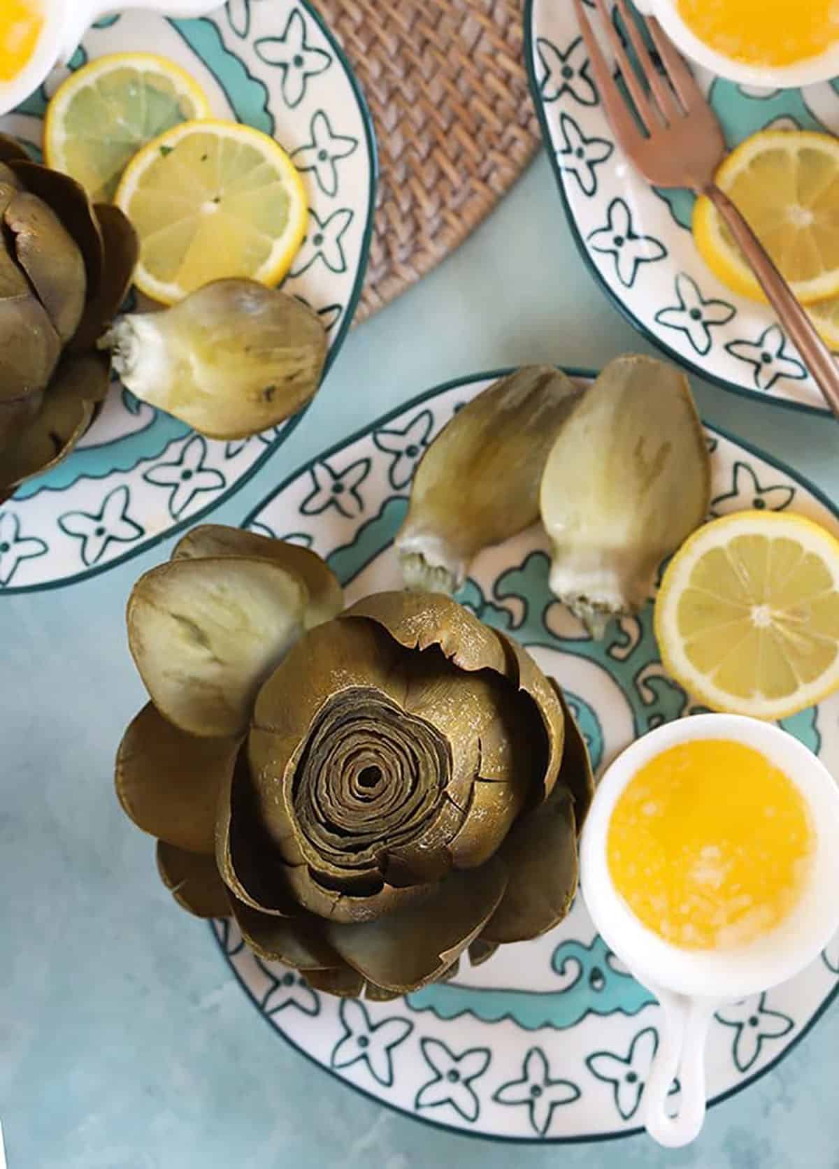 Instant Pot Artichokes with butter in a white dish.