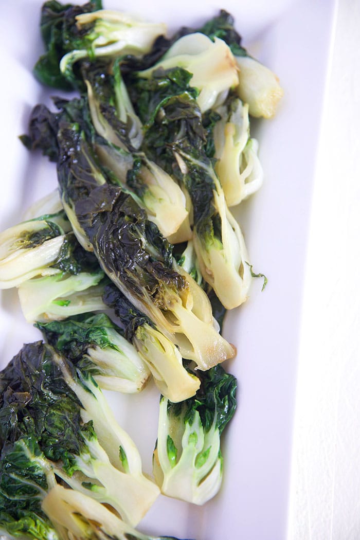 Multiple pieces of sautéed Bok Choy are placed on a serving dish.