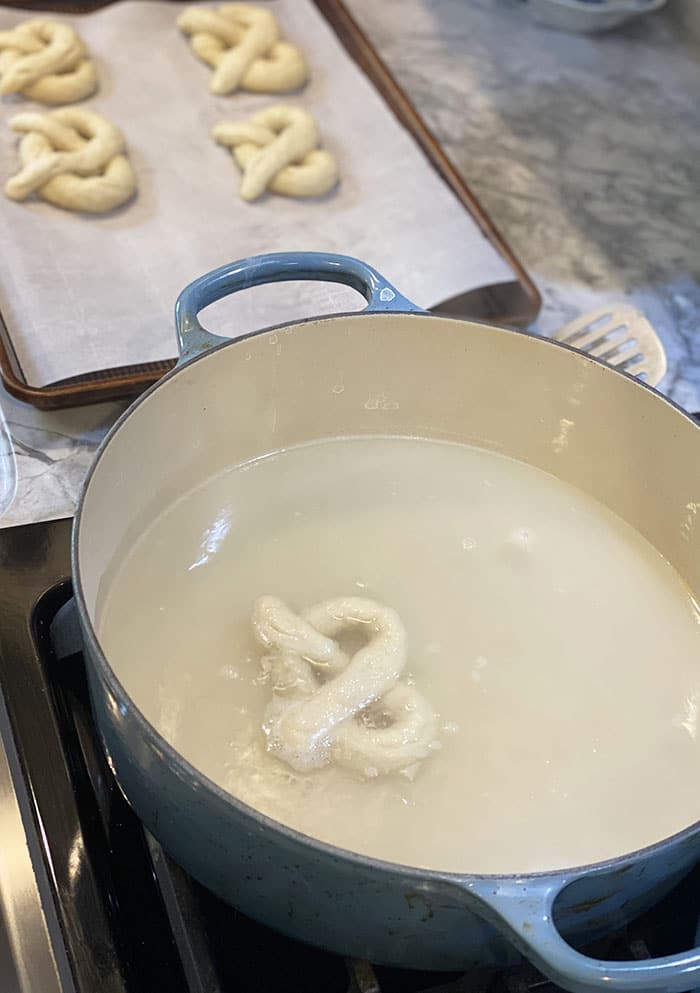 Soft pretzels being boiled in baking soda water.