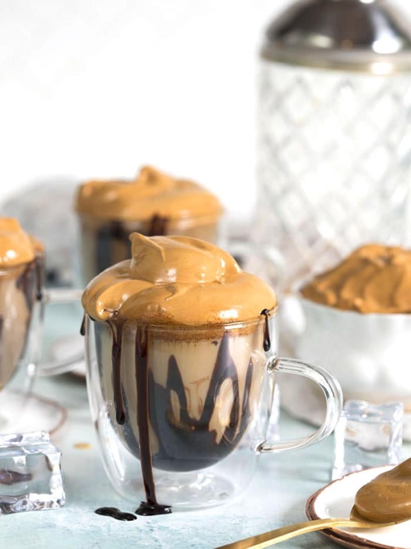 Whipped Coffee Mudslide Cocktail in a glass mug with chocolate syrup on the sides.