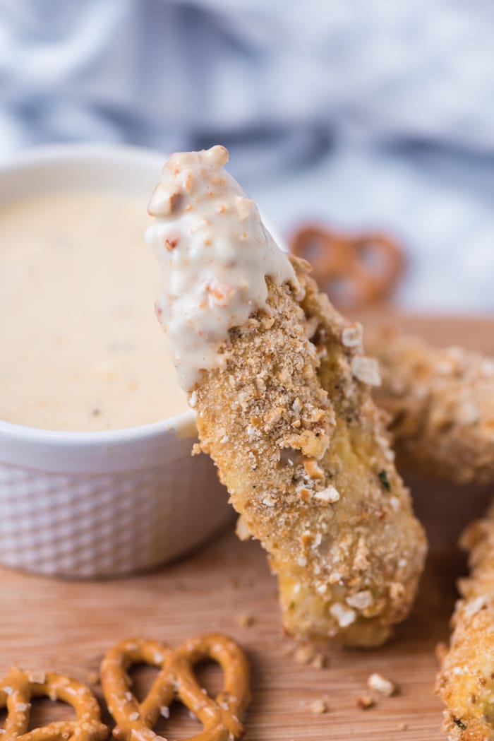 Pretzel crusted chicken tender with dipping sauce.
