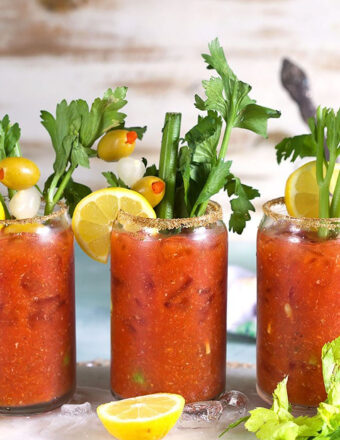 Bloody Mary Mix in a glass with celery and olives.