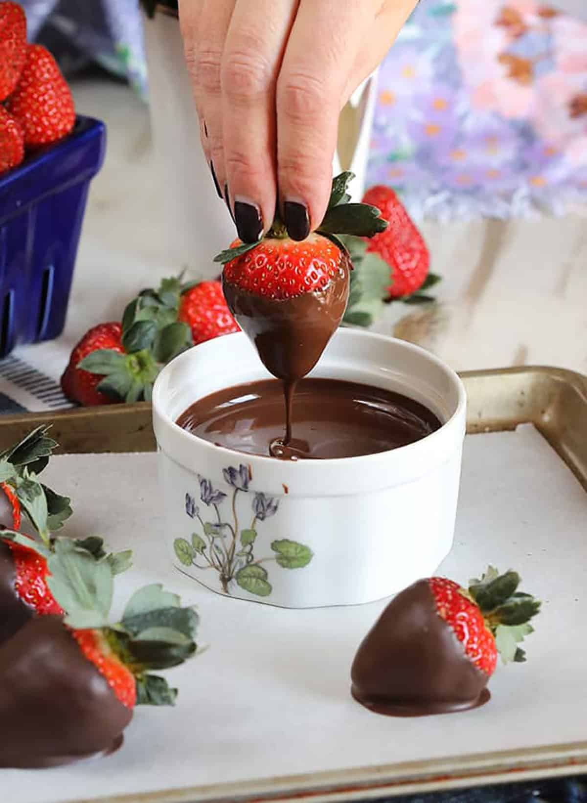 Strawberry being dipped in melted chocolate