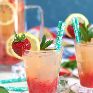 strawberry lemonade in a glass with strawberry garnish and a straw