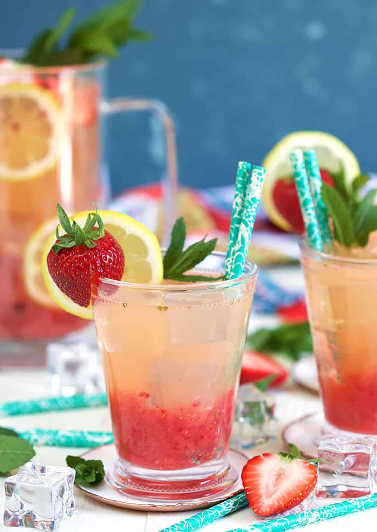 strawberry lemonade in a glass with strawberry garnish and a straw