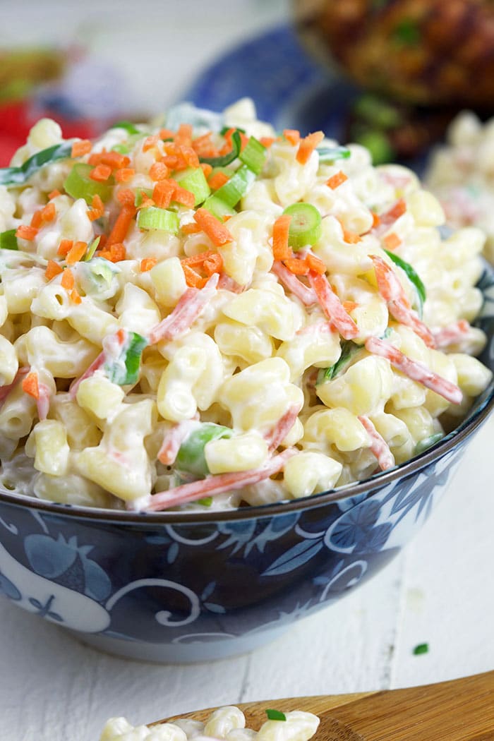 Close up of macaroni salad in a blue and white bowl.