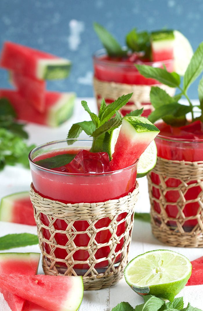 Watermelon agua fresca in a seagrass glass with watermelon garnish.