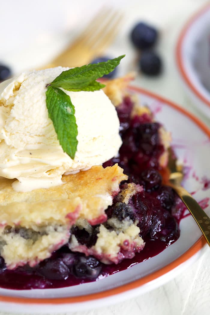 Close up of blueberry dump cake with ice cream on top.