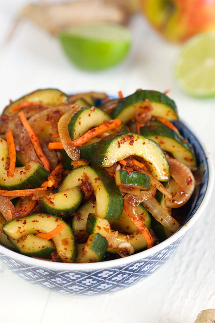 Cucumber Kimchi in a blue and white bowl on a white background.