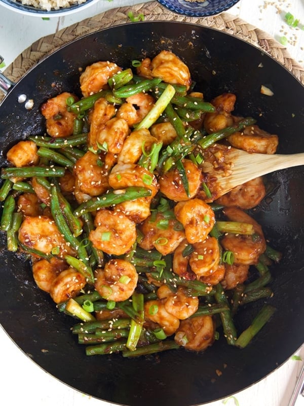 Overhead shot of Hunan Shrimp in a black stir fry pan.