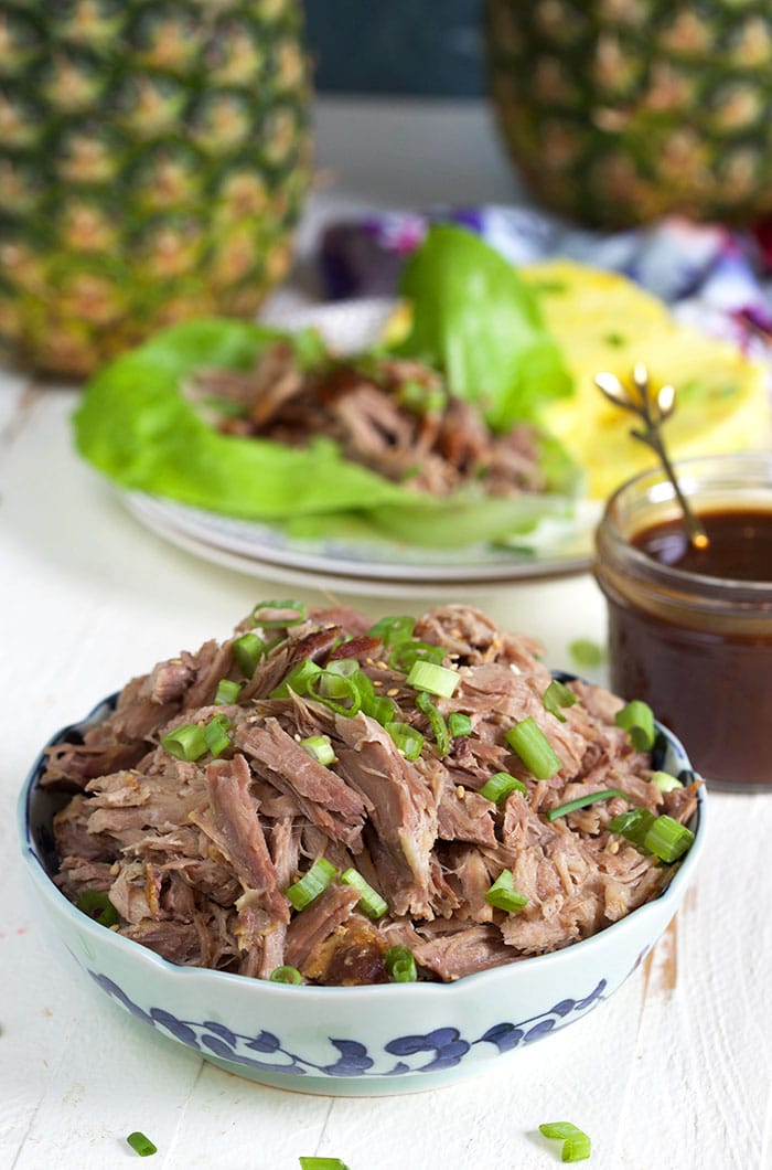Kalua pork in a blue and white bowl on a white background.