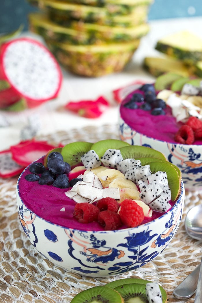 two bowls of Pitaya smoothie bowls with fresh fruit on top
