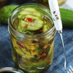 jar of pickles with a cute cocktail fork leading on the side.