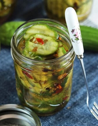 jar of pickles with a cute cocktail fork leading on the side.
