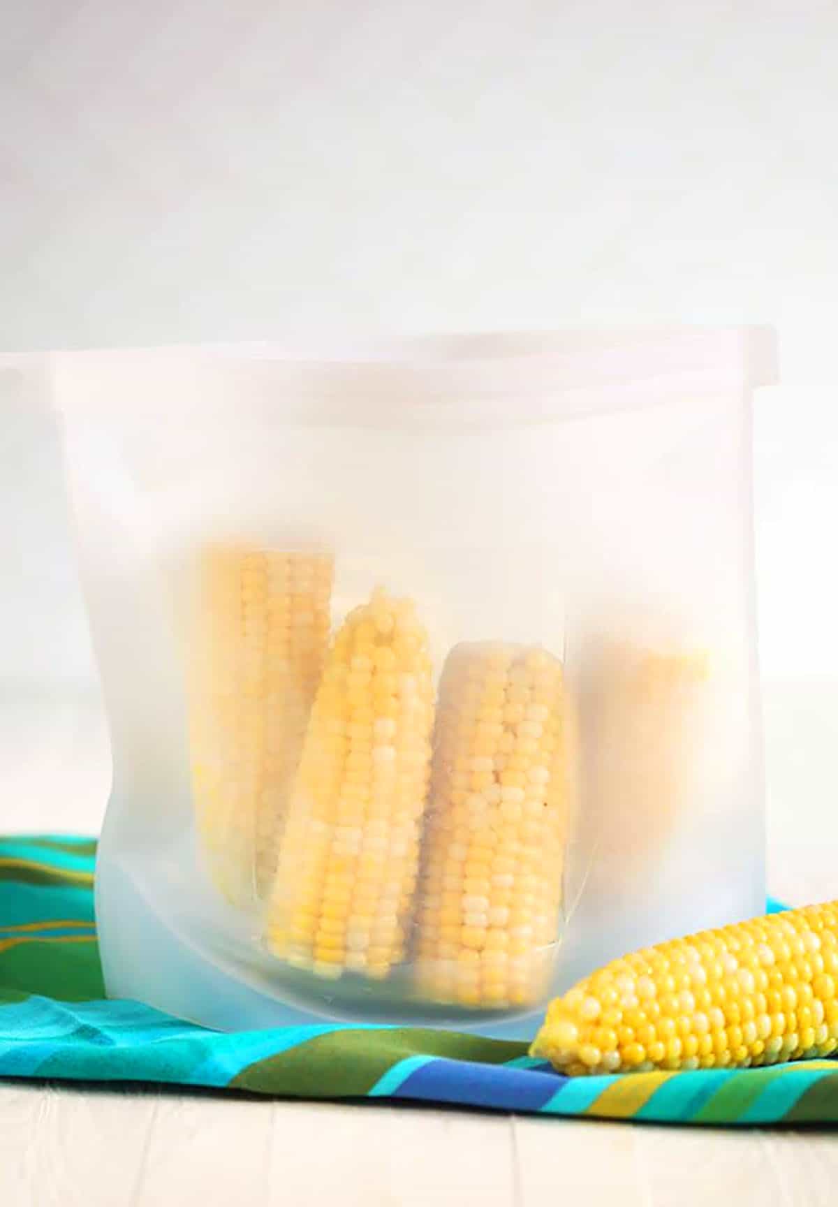 Corn on the cob in a zip top silicone freezer bag.