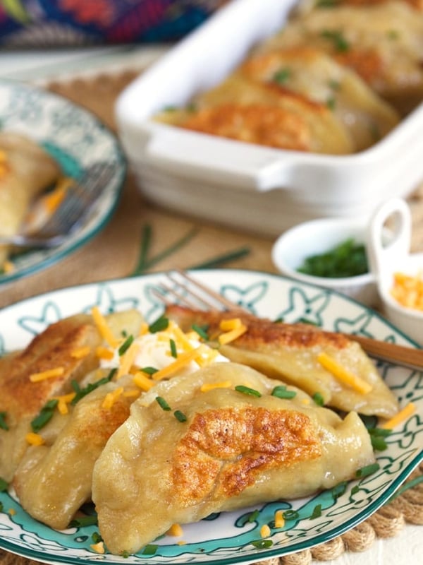 Loaded Baked Potato Pierogi on a blue and white plate.