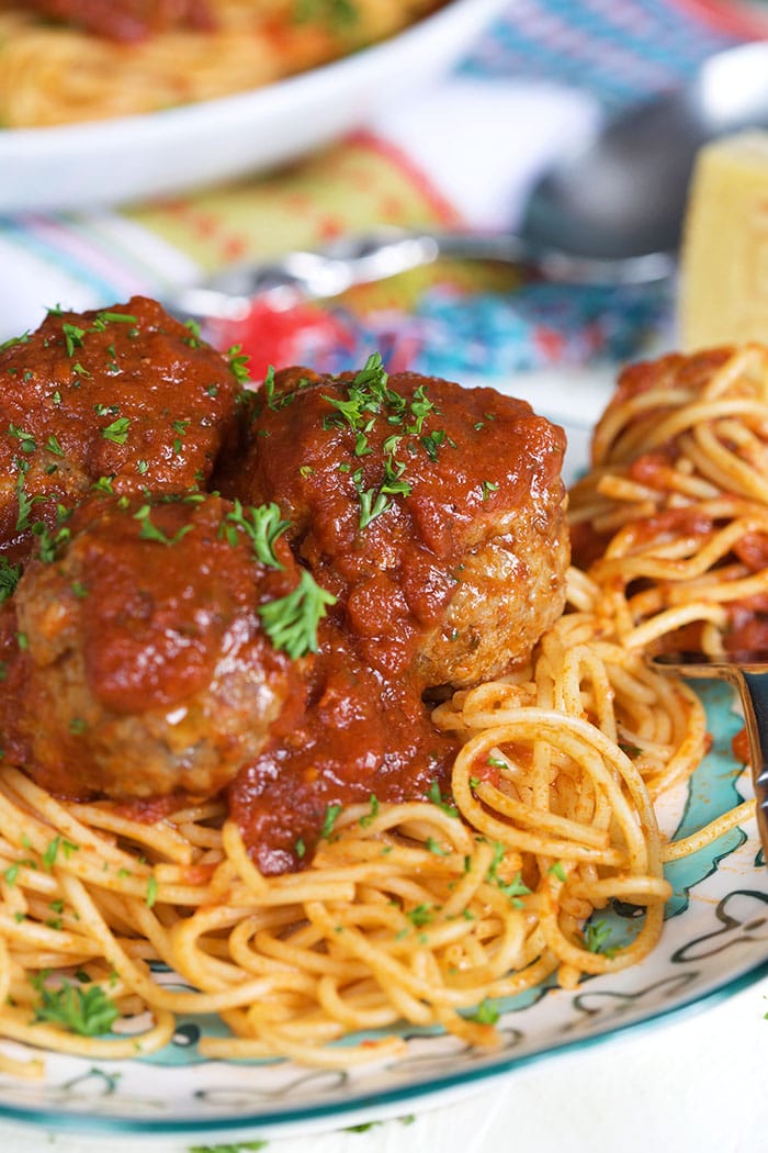 Pan Fried Meatballs on a plate of spaghettini with a fork twirled with pasta.